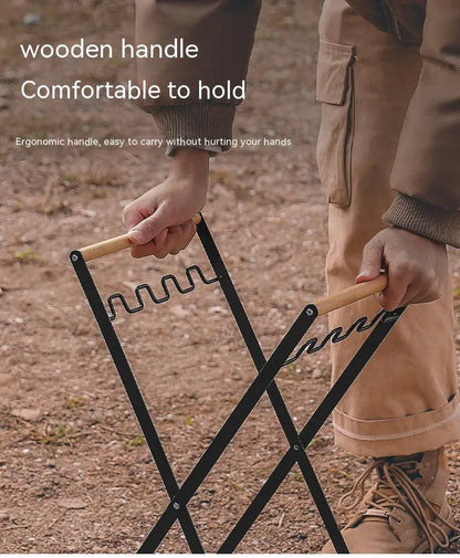 Black outdoor folding trash rack with wooden handle, holding a waste bag.