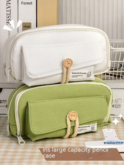 Korean style canvas pencil case with button closure, shown in beige, holding multiple pens.
