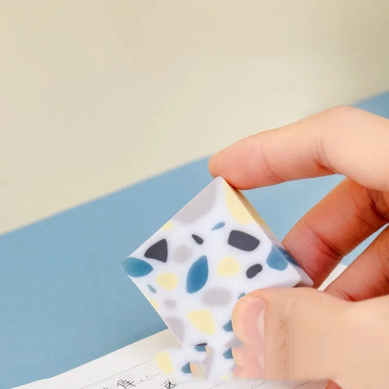 White rectangular rubber brick eraser for students on a blue background.