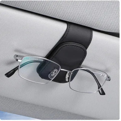 Car sunglasses holder clip with PU leather case attached to a sun visor.