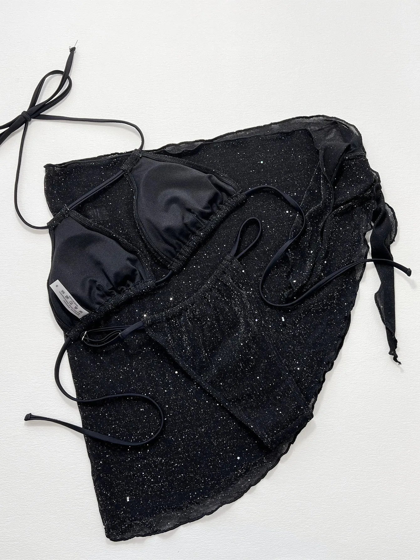 Black three-piece fission style swimsuit bikini set with top and shorts on a mannequin.