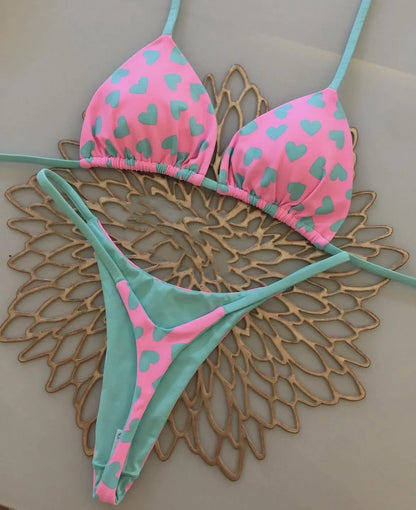 Heart print women's backless one-piece swimsuit with split sides on a mannequin
