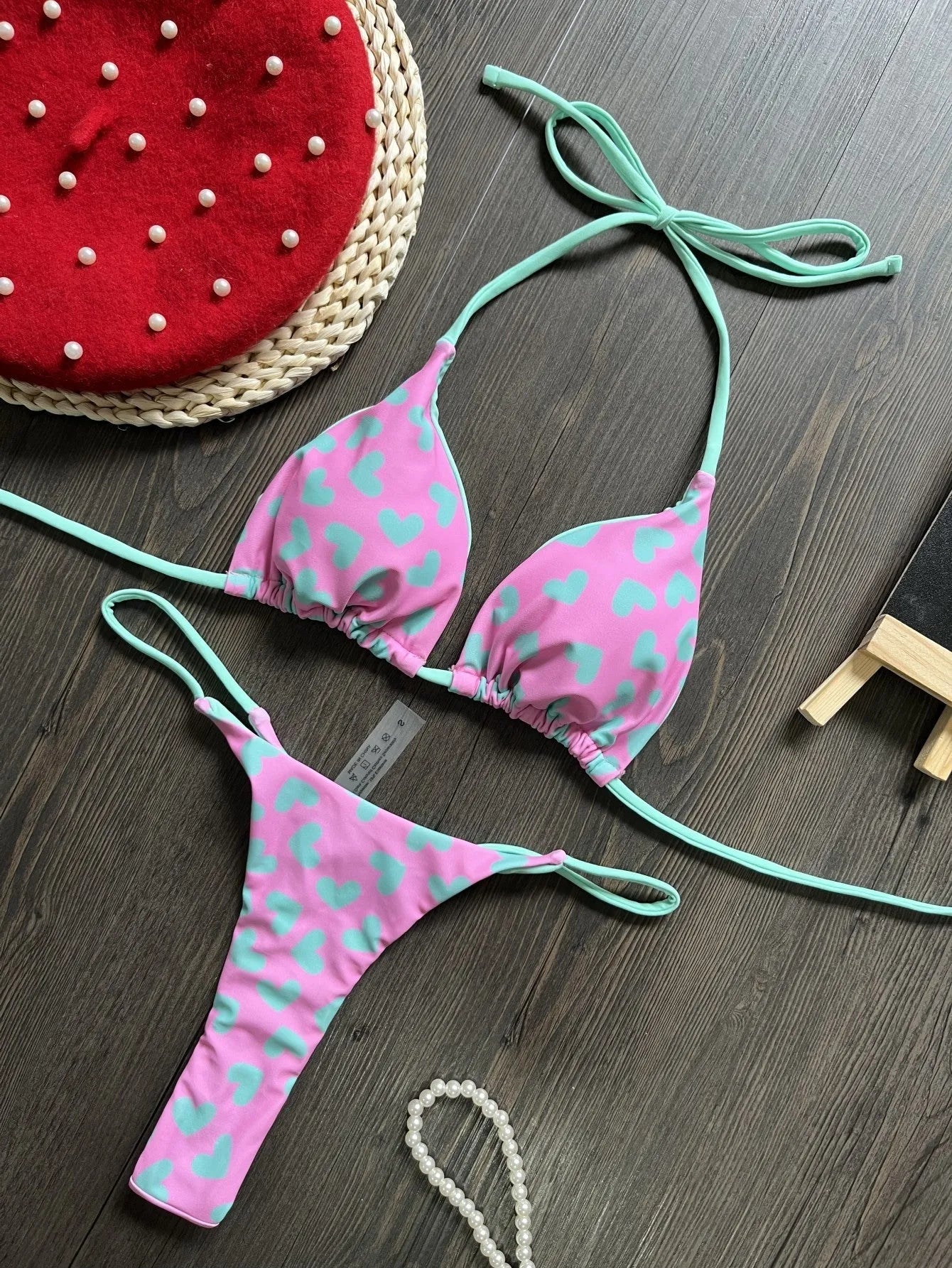 Heart print women's backless one-piece swimsuit with split sides on a mannequin