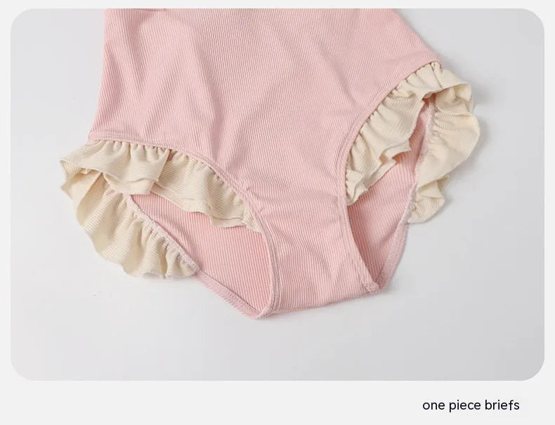 Pink women's conservative one-piece swimsuit with Siamese design on a hanger