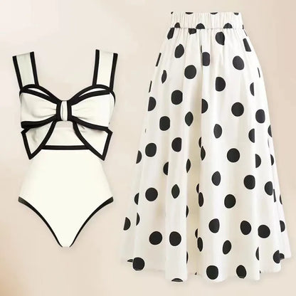 Women's black one-piece swimsuit with white attached round skirt and decorative bow at front