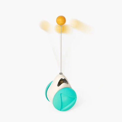 Cat playing with rotating windmill toy featuring luminous balls and suction base