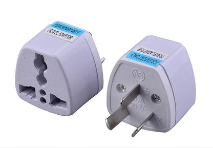 Black and white travel power adapter with three AC sockets showing AU EU US plug options