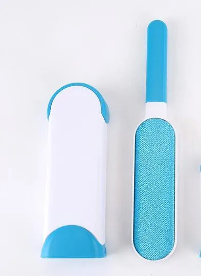 Blue reusable pet hair removal brush with double-sided head next to its self-cleaning base.