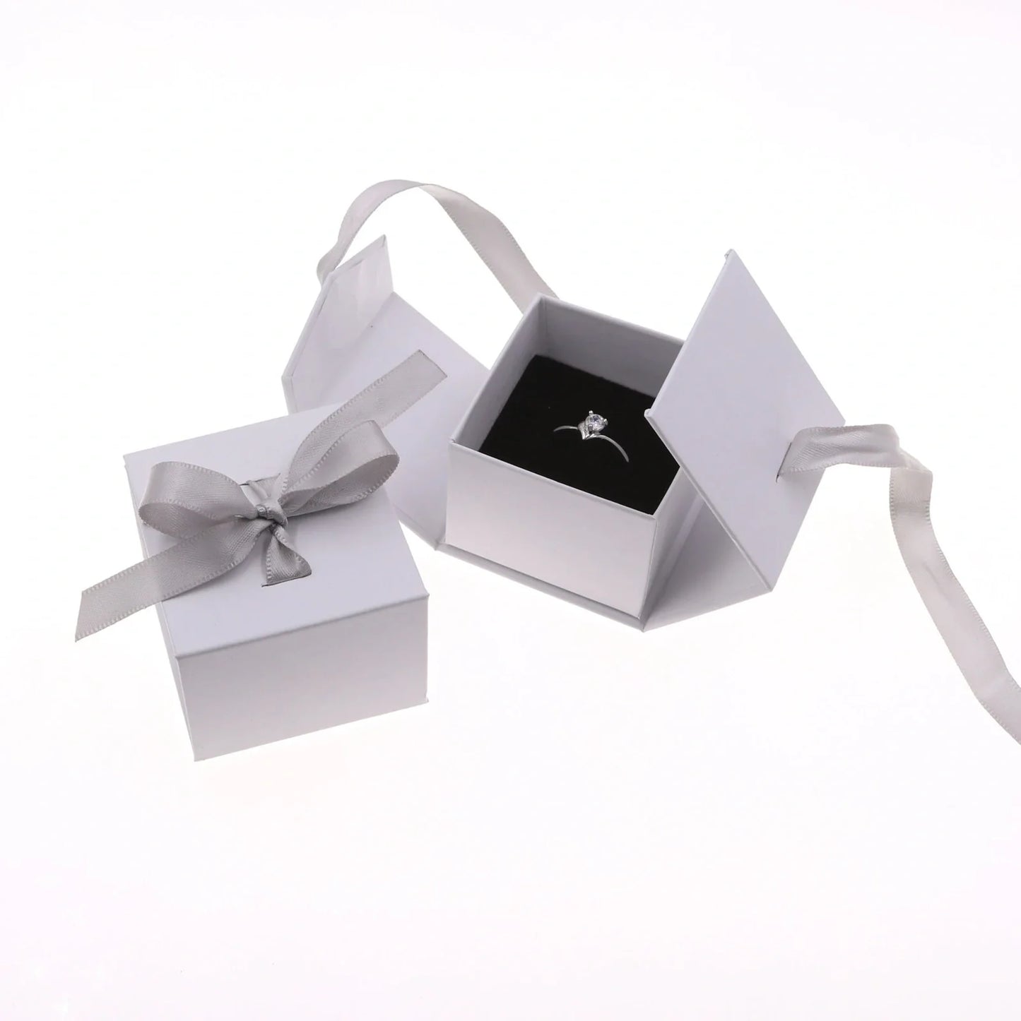 Grey square jewellery box with white ribbon bow measuring 5x5x4cm with sponge-lined interior