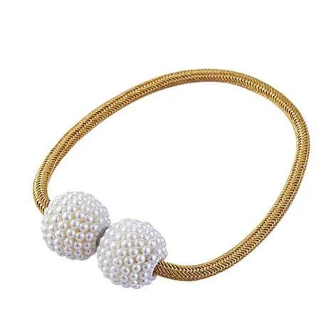 Magnetic curtain tiebacks with white pearl beads and fabric loops holding gathered curtain