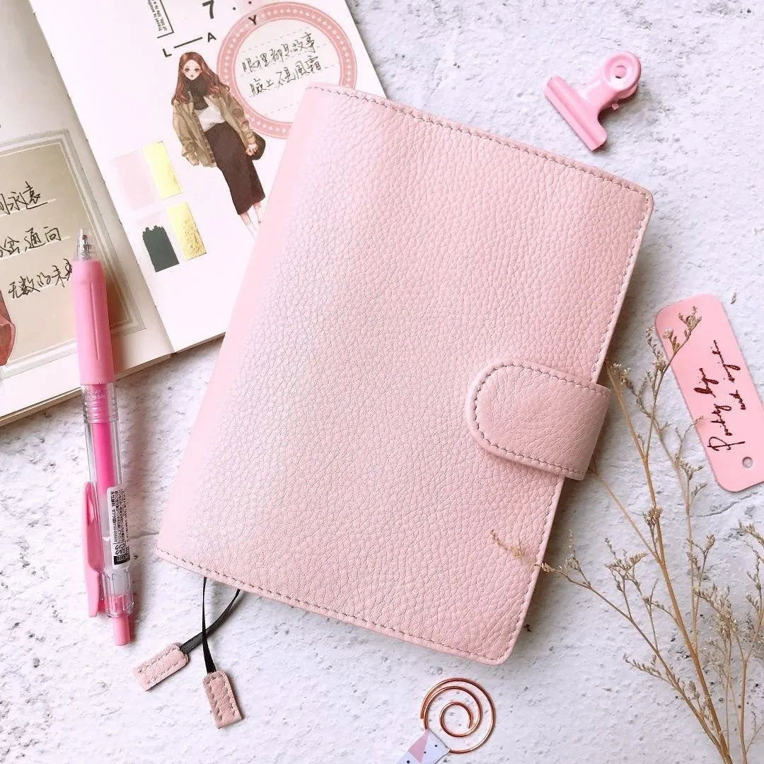 Close-up of a hand-embossed lychee pattern on an off-white A6 cowhide leather notebook with loose-leaf binding.