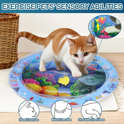 Blue ocean-themed cat water play mat with floating fish toys inside an inflated square border on a wooden floor.