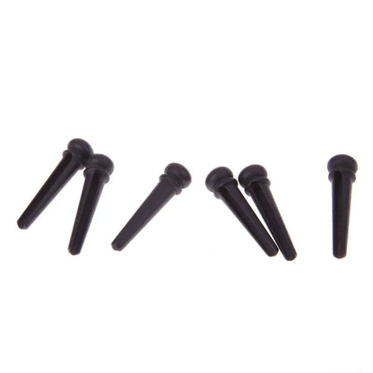 Six ebony folk guitar string nails with matte black finish and 5.3mm bayonet diameter