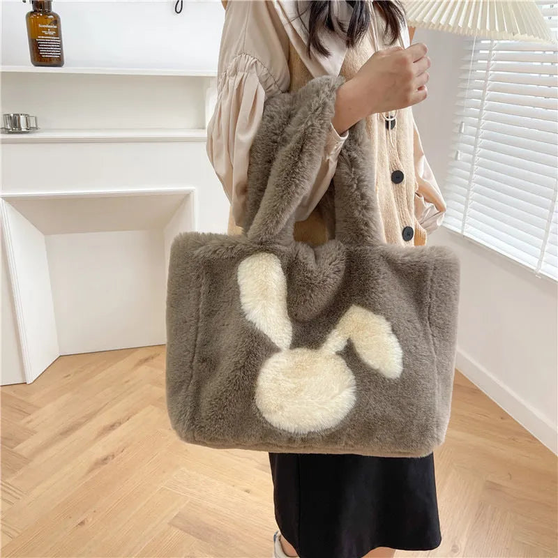 Soft plush tote bag with cartoon rabbit ears in solid colours like beige, pink, and black.