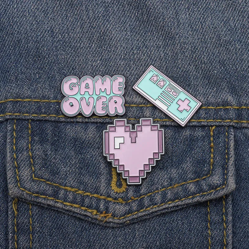 Stereo game console badge made of alloy metal for bag or jacket attachment.