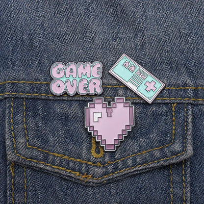 Stereo game console badge made of alloy metal for bag or jacket attachment.