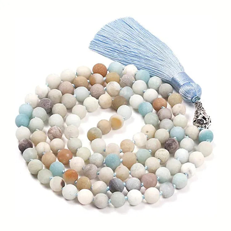 Long multi-coloured agate and stone tassel necklace with geometric beads on a white background.