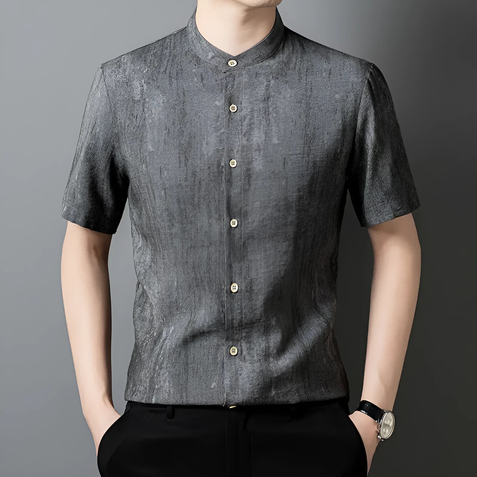 Man wearing a loose-fit grey linen blend short-sleeve shirt with a stand collar.