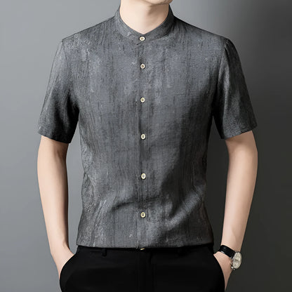 Man wearing a loose-fit grey linen blend short-sleeve shirt with a stand collar.