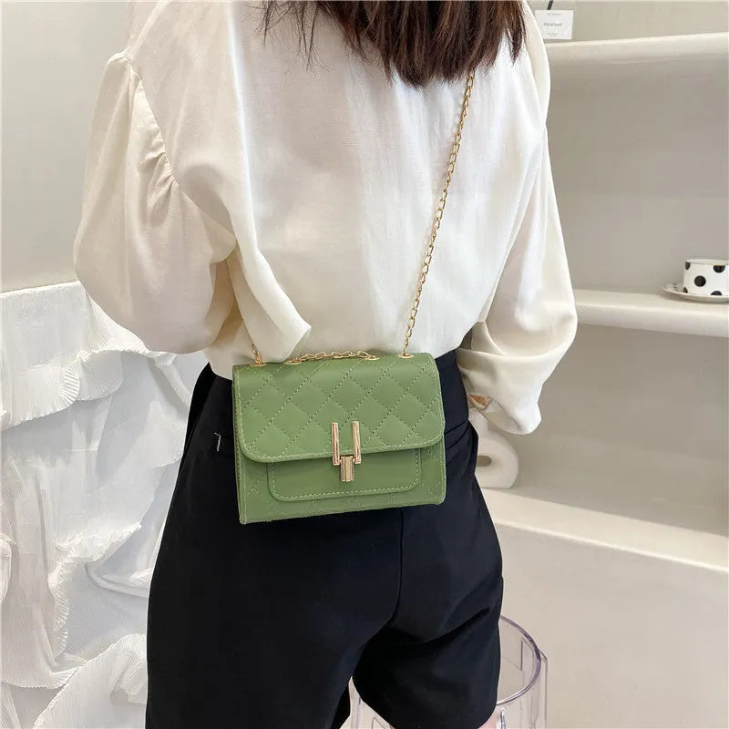Crossbody bag for women, made from vegan PU leather, featuring a diamond lattice chain shoulder strap, with dimensions of 17.5cm upper width, 13cm height, and 7cm thickness, in a minimalist solid colour design, available in black, white, or green.