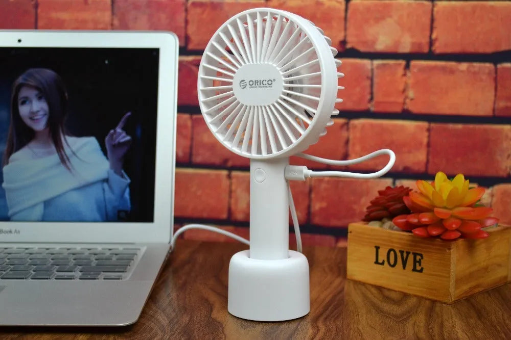 White ORICO FH1 portable USB rechargeable desk and handheld small fan with three speed buttons.