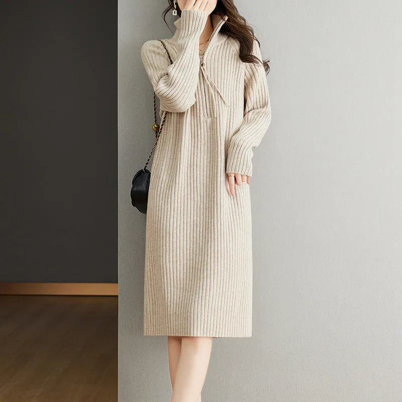 Beige half-zip woolen skirt with long sleeves, a stand collar, and a loose, straight midi silhouette.