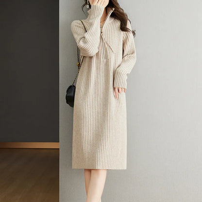 Beige half-zip woolen skirt with long sleeves, a stand collar, and a loose, straight midi silhouette.