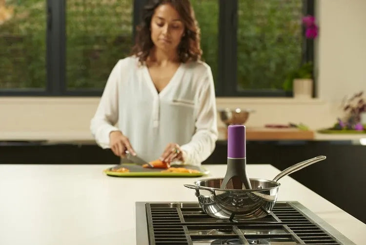 Uutensil Stirr automatic pot stirrer in grey placed inside a saucepan stirring sauce.