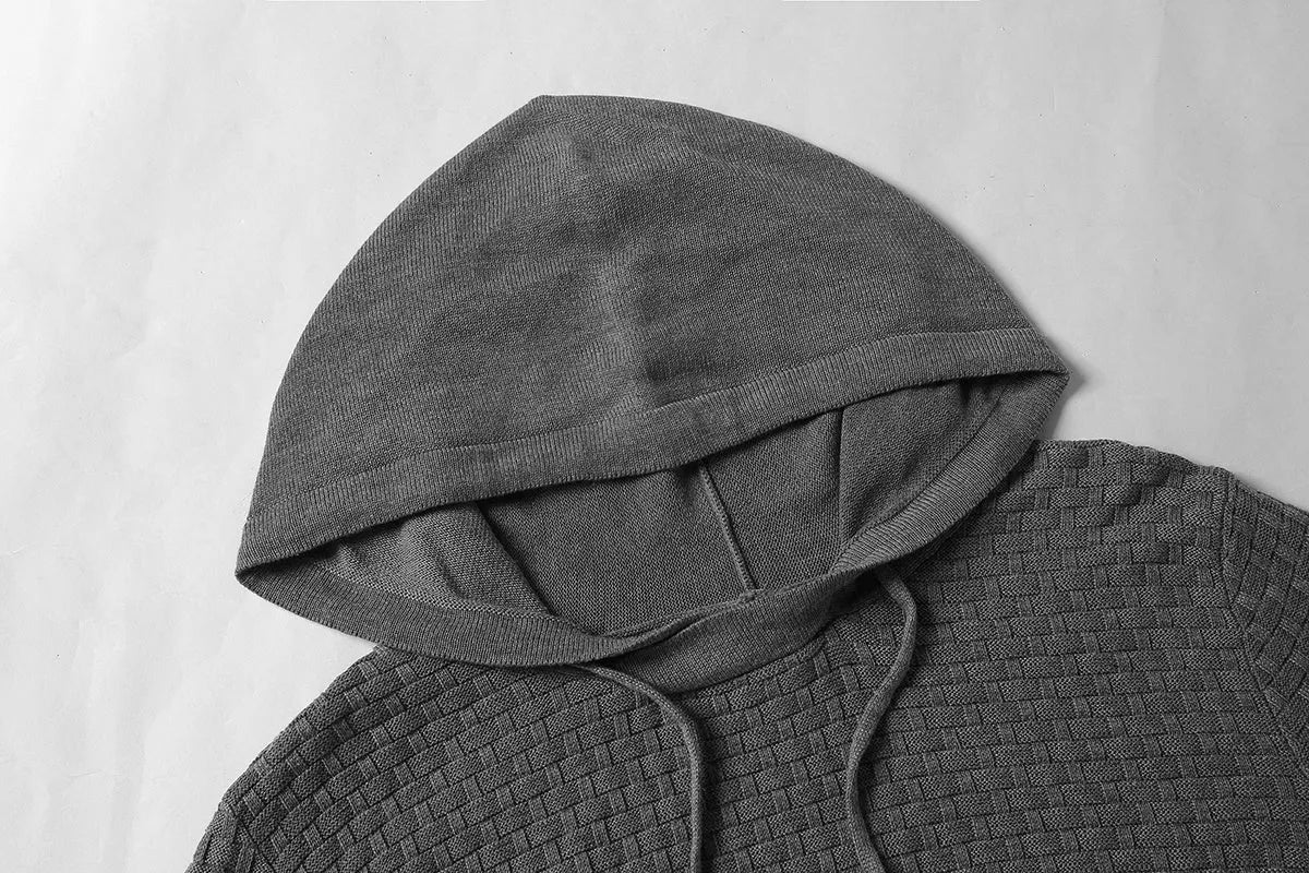 A man wearing a cotton-polyester blend hoodie available in nine colours including black, navy, and red.