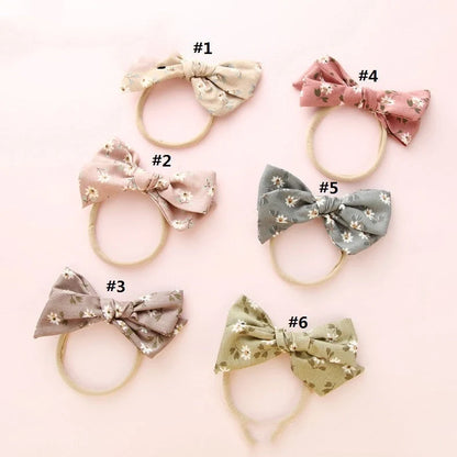 Children's cloth hair band with knotted bow design in one of six colour options