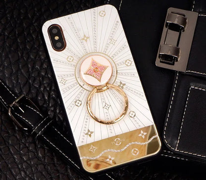 Luxury diamond and gold ring stand attached to the back of an iPhone in rose gold colour.
