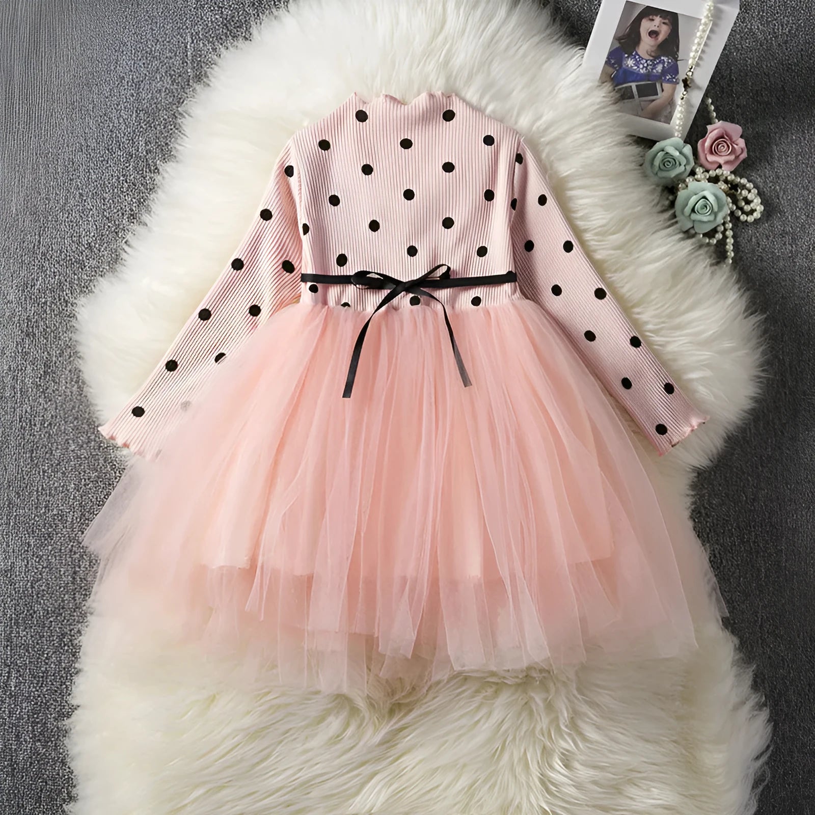 Baby girl wearing a long sleeve black tutu dress with lace detail for a birthday party.