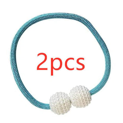 Magnetic curtain tiebacks with white pearl beads and fabric loops holding gathered curtain