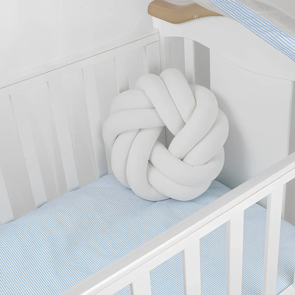 Knotted lumbar pillow with memory foam fill showing adjustable height feature and polyester cover