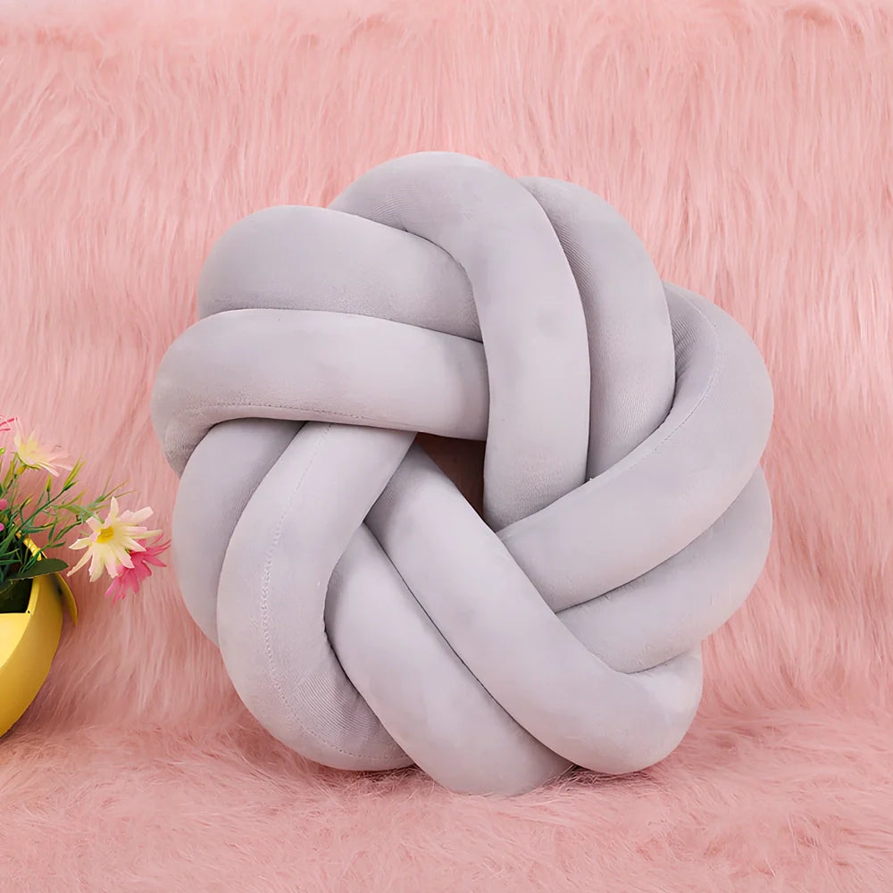 Knotted lumbar pillow with memory foam fill showing adjustable height feature and polyester cover