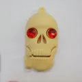 Skull-shaped black USB flash drive on a small metal keychain against a dark background.