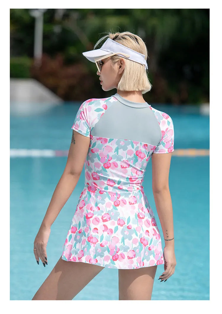 Printed plus size one-piece swimsuit on hanger, showing colourful pattern.