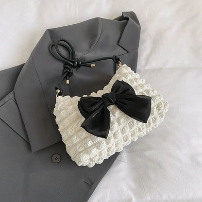 Women's black canvas single shoulder handbag with a sandwich pocket and horizontal square shape.