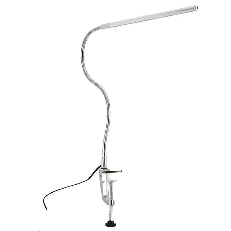 Silver aluminium alloy USB-powered LED nail table lamp with a long arm clip attached to a table edge.