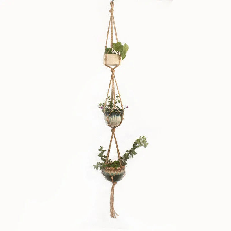 Handwoven natural cotton rope plant hanger cradling a green potted succulent on a wooden table.