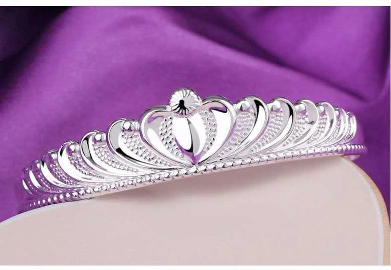 A close-up view of the elegant Crown Bracelet, showcasing its intricate crown-shaped design and shiny, rhodium-plated finish.