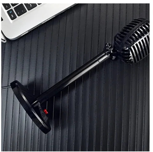 Black USB computer microphone with adjustable gooseneck and weighted silicone base stand on a desk.