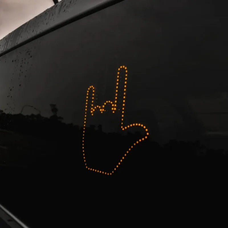 Black plastic LED gesture car light showing illuminated hand symbol, with remote control.