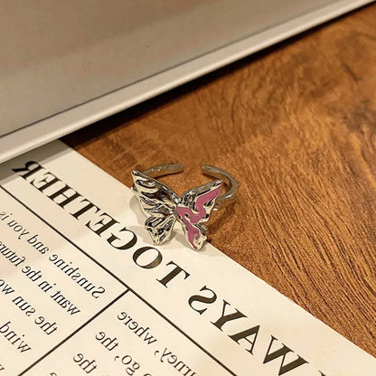 Copper butterfly women's ring with an open loop design on a plain background.