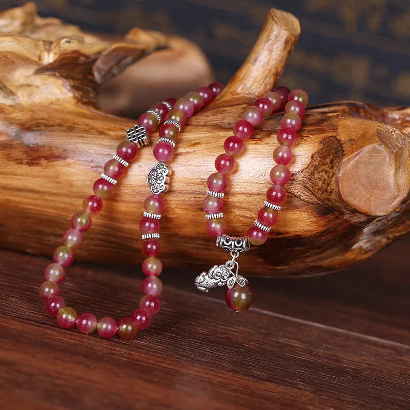 Handmade bracelet with green and pink watermelon crystal beads tied with Chinese knots.