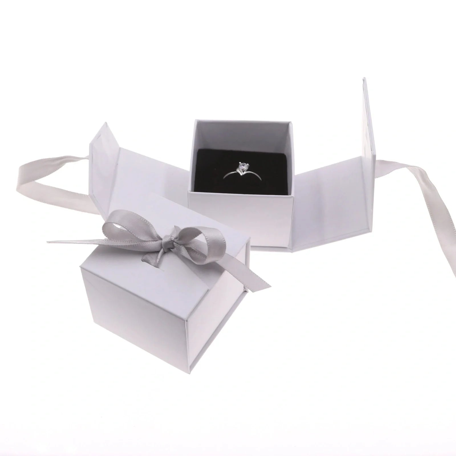 Grey square jewellery box with white ribbon bow measuring 5x5x4cm with sponge-lined interior