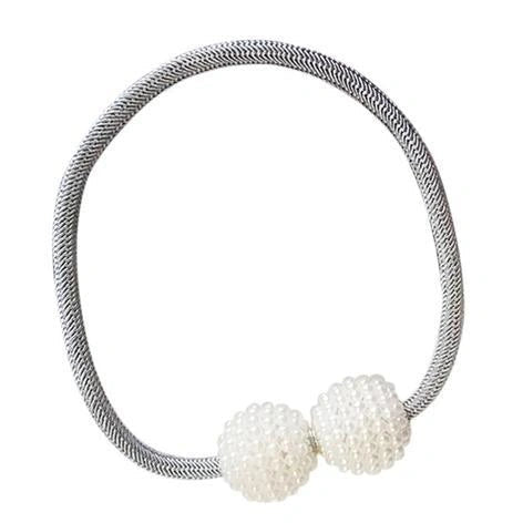 Magnetic curtain tiebacks with white pearl beads and fabric loops holding gathered curtain