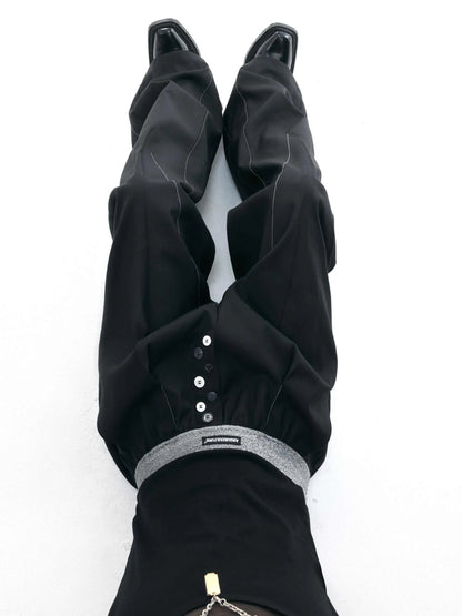 Straight-leg trousers with button-open line detail in black and grey colours, showing high-waist design and tailored silhouette
