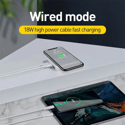 Small square black wireless charging power bank with LED display showing battery percentage.