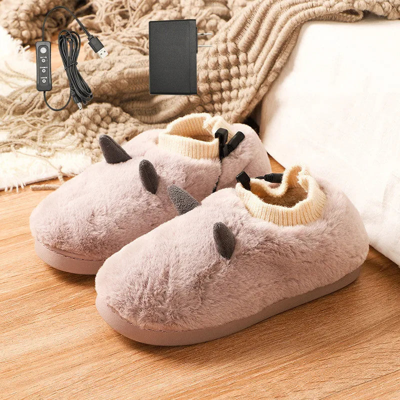 USB heating slippers in black plugged into a laptop, showing the cable and soft velvet upper.